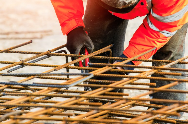 Steel fixer assembling reinforcement cage off rebars.